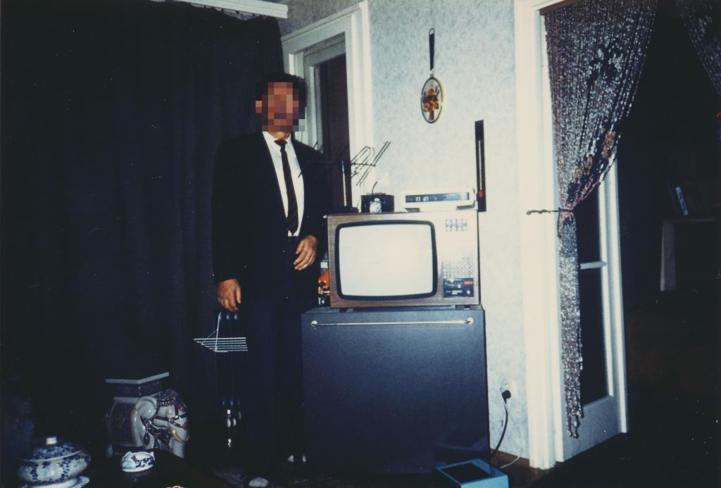 Érintőgombos televíziókészülék szobaantennával, modern kivitelű ledkijelzős rádiós órával és elegáns úrral